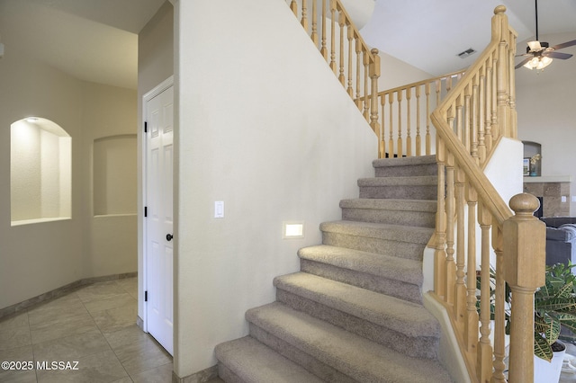 stairs featuring tile patterned floors and ceiling fan