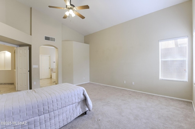 carpeted bedroom with ceiling fan, high vaulted ceiling, and ensuite bath