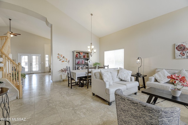 living room featuring french doors, high vaulted ceiling, ceiling fan with notable chandelier, and a wealth of natural light