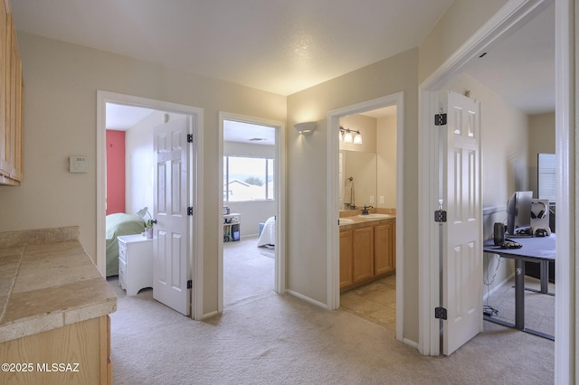 hall featuring light carpet and sink