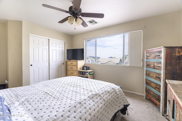 bedroom featuring light carpet, ceiling fan, and a closet