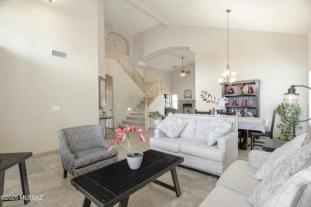 living room featuring ceiling fan with notable chandelier, high vaulted ceiling, and light tile patterned flooring