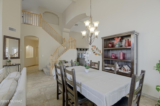 dining space with an inviting chandelier, light tile patterned floors, and a high ceiling