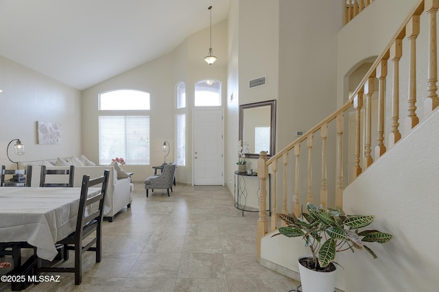 entrance foyer featuring a towering ceiling and light tile patterned floors