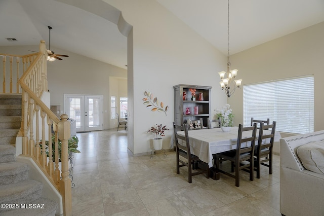 dining space featuring light tile patterned flooring, ceiling fan with notable chandelier, high vaulted ceiling, and french doors