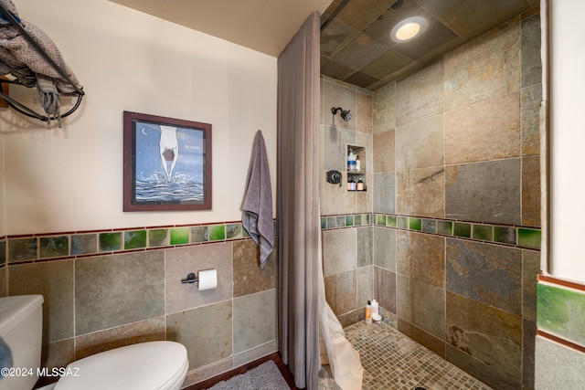 bathroom with tile walls, curtained shower, and toilet