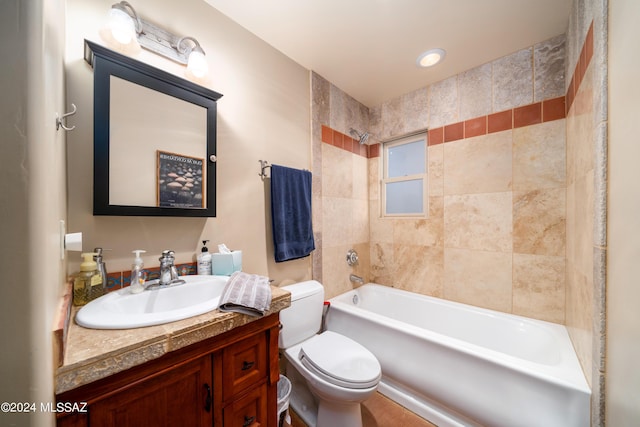 full bathroom with tiled shower / bath, vanity, and toilet