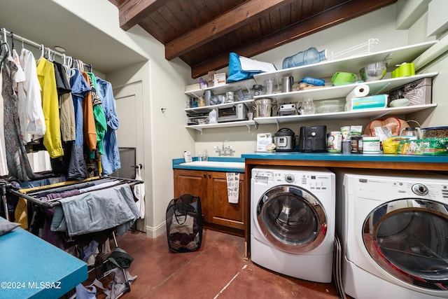 clothes washing area featuring sink, washing machine and clothes dryer, and wood ceiling