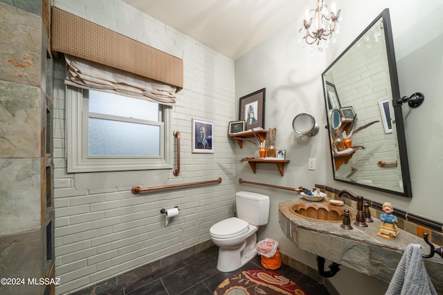 bathroom featuring tile patterned flooring, sink, a notable chandelier, and toilet