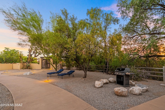 patio terrace at dusk featuring area for grilling