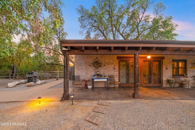 back house at dusk with a patio area