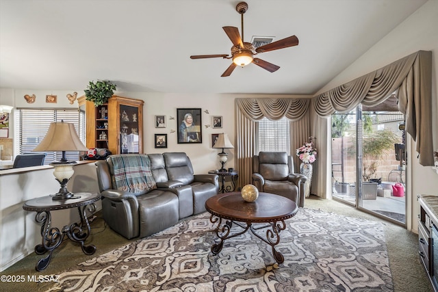 carpeted living room with ceiling fan and vaulted ceiling