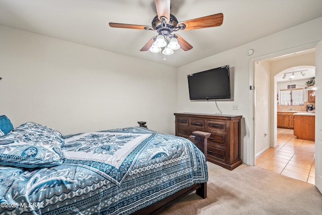 carpeted bedroom featuring ensuite bathroom and ceiling fan