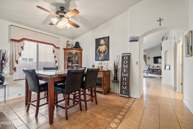 dining area featuring vaulted ceiling, light tile patterned floors, and ceiling fan