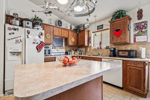 kitchen with lofted ceiling, sink, decorative backsplash, light tile patterned floors, and white appliances