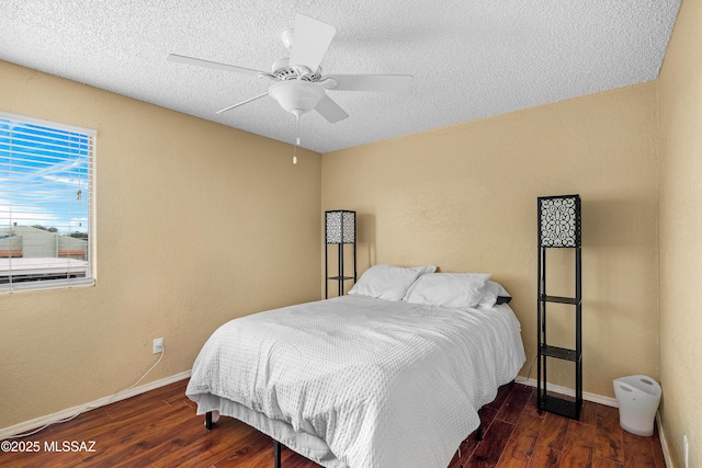 bedroom with ceiling fan, dark hardwood / wood-style flooring, and a textured ceiling