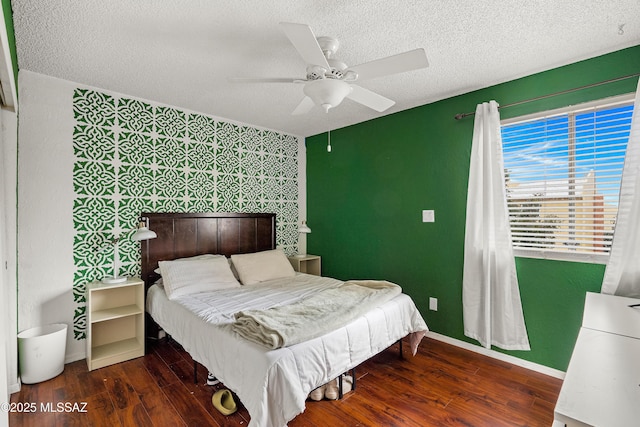 bedroom with dark hardwood / wood-style floors, a textured ceiling, and ceiling fan