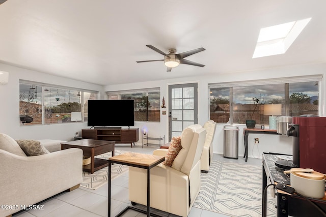 living room featuring a wall unit AC, ceiling fan, and a skylight