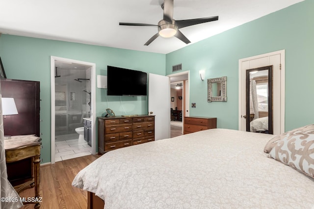 bedroom featuring hardwood / wood-style flooring, lofted ceiling, connected bathroom, and ceiling fan