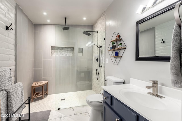 bathroom featuring vanity, toilet, and tiled shower