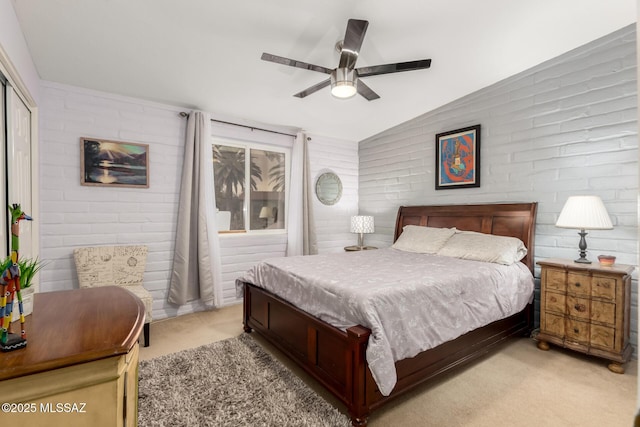 bedroom featuring brick wall, lofted ceiling, and light carpet