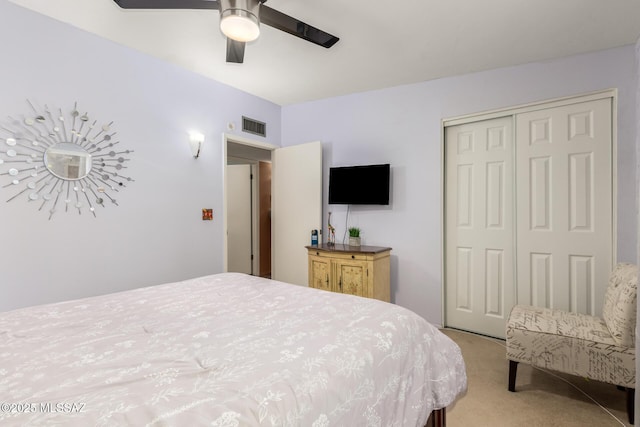 carpeted bedroom with ceiling fan and a closet