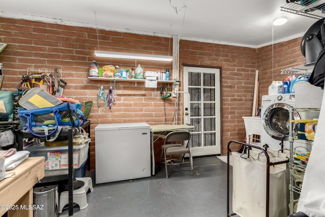 clothes washing area featuring brick wall