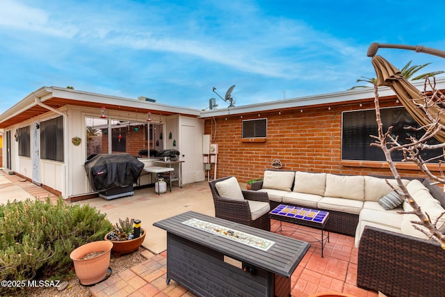 view of patio with a grill and an outdoor living space with a fire pit