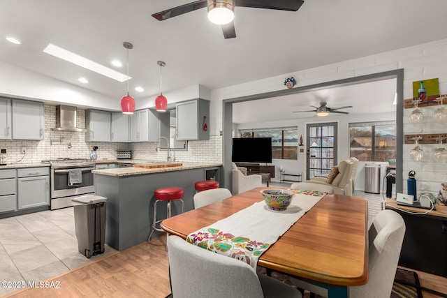 dining room with ceiling fan, light hardwood / wood-style floors, and sink