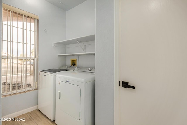 laundry area with light hardwood / wood-style flooring and washer and clothes dryer