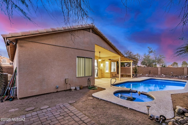 exterior space with an in ground hot tub, ceiling fan, central AC unit, and a patio