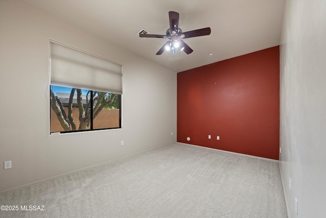 carpeted spare room featuring ceiling fan