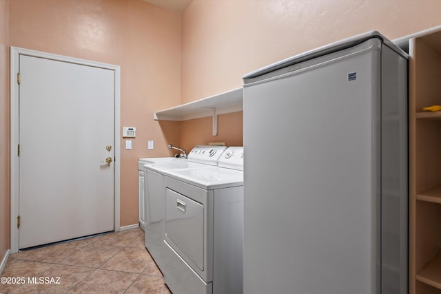 laundry area featuring light tile patterned floors and washer and clothes dryer