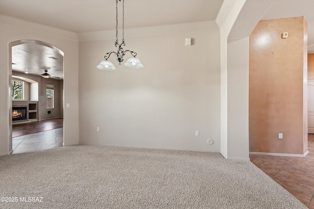 carpeted spare room with ceiling fan