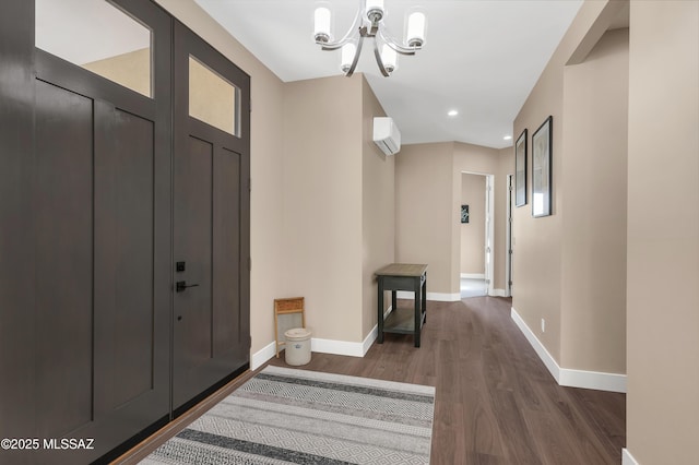 entryway with a chandelier, dark hardwood / wood-style flooring, and a wall mounted AC