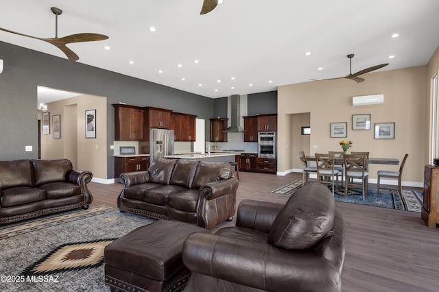 living room with dark hardwood / wood-style flooring, a wall mounted air conditioner, and ceiling fan