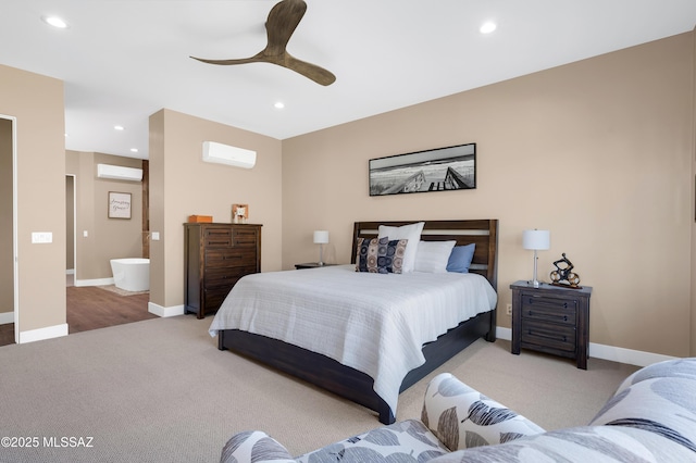 carpeted bedroom with ceiling fan, ensuite bathroom, and a wall mounted AC