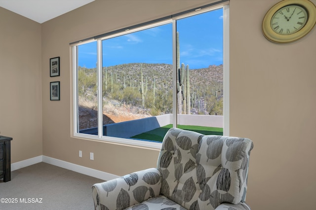 living area with a mountain view and carpet