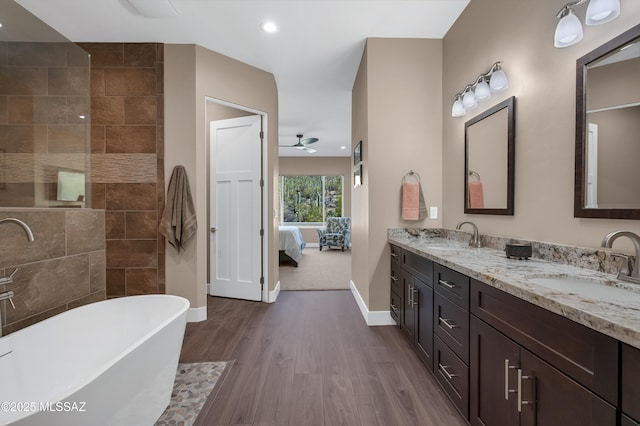 bathroom featuring a bathing tub, hardwood / wood-style floors, vanity, and ceiling fan