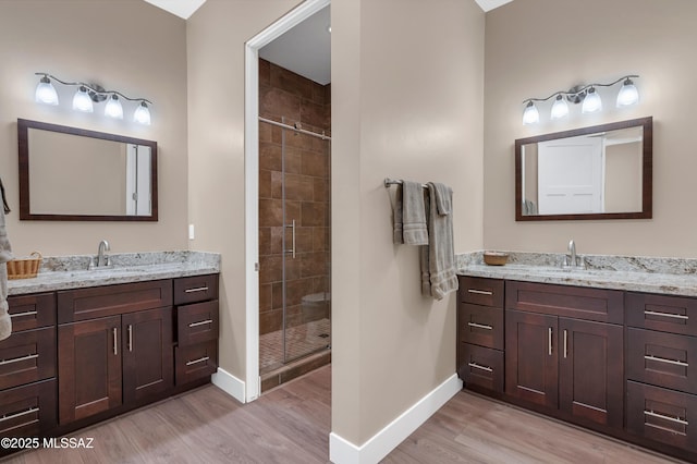 bathroom featuring an enclosed shower, vanity, and hardwood / wood-style flooring