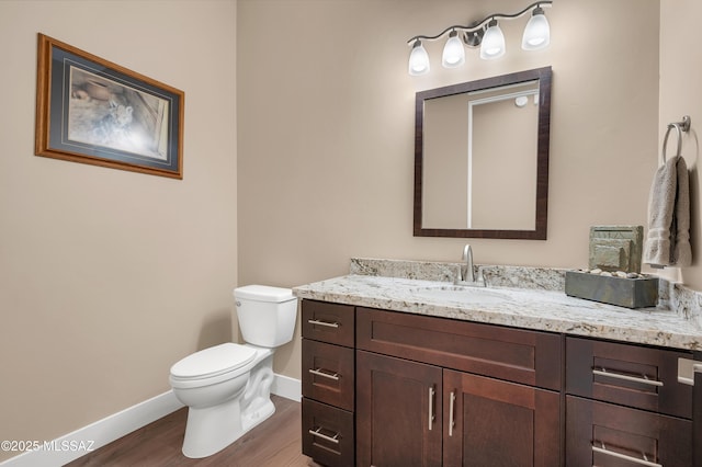 bathroom with vanity, toilet, and hardwood / wood-style floors