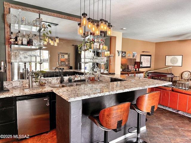 bar featuring sink, dishwasher, pendant lighting, and light stone countertops