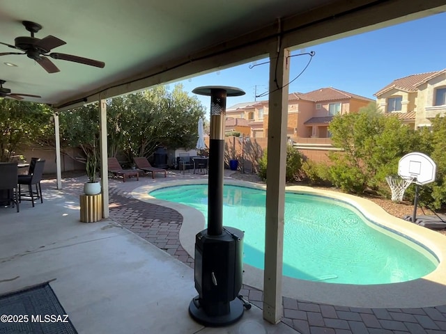 view of swimming pool featuring ceiling fan and a patio area