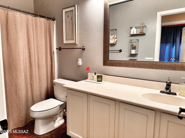 bathroom with toilet, vanity, and walk in shower