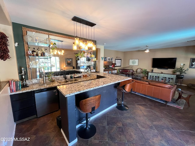 kitchen with a kitchen breakfast bar, light stone countertops, stainless steel dishwasher, decorative light fixtures, and a center island