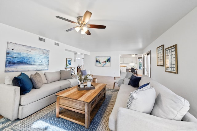 living room featuring wood-type flooring and ceiling fan