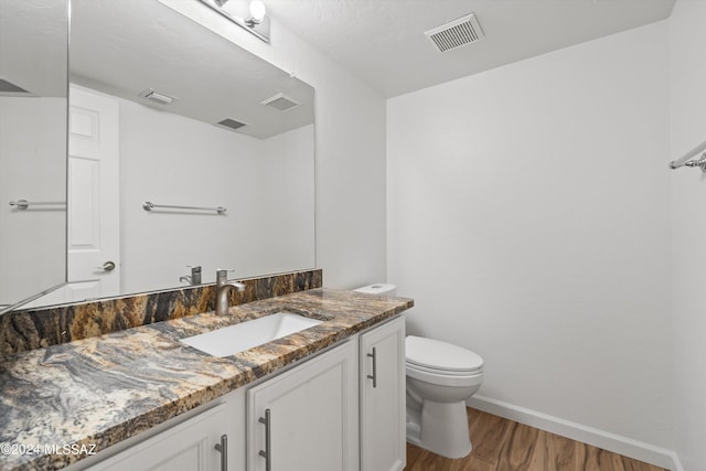 bathroom with vanity, wood-type flooring, and toilet