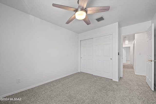 unfurnished bedroom with light carpet, ceiling fan, and a closet