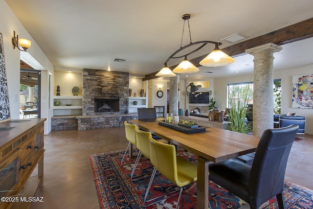 dining space featuring visible vents, finished concrete flooring, a fireplace, and decorative columns