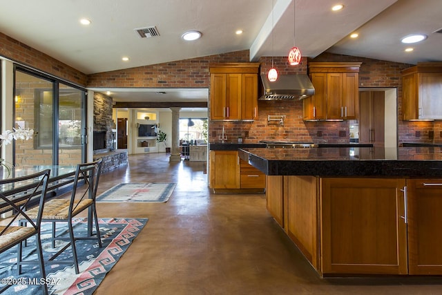 kitchen with dark countertops, brick wall, visible vents, and lofted ceiling